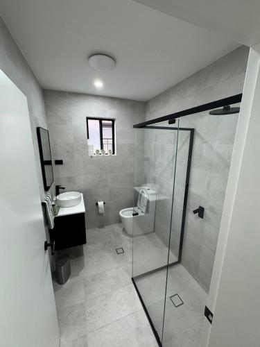 a bathroom with a toilet and a glass shower at HOME away from HOME in Sydney