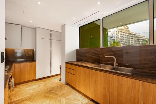 a kitchen with a sink and a large window at FIVE Palm Residence - Elegant Homes in Dubai