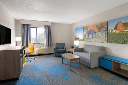 a living room with a couch and a tv at Days Inn by Wyndham Davenport in Davenport