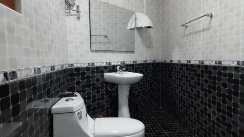 ein Badezimmer mit einem weißen WC und einem Waschbecken in der Unterkunft White City Inn in Gaborone