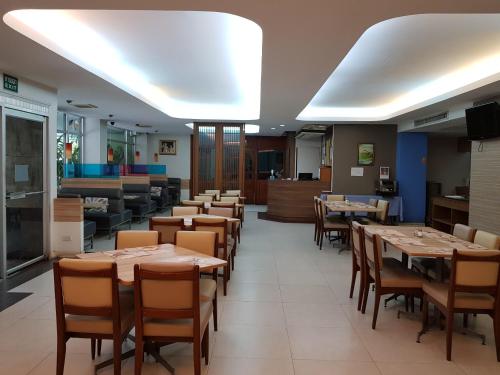 une salle à manger avec des tables et des chaises en bois dans l'établissement Florida Hotel, à Bangkok