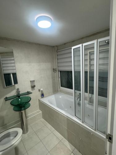 a bathroom with a tub and a toilet and a sink at Systematic Home in Battlesbridge