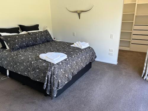 a bedroom with a bed with two towels on it at Cambridge Lodge in Cambridge