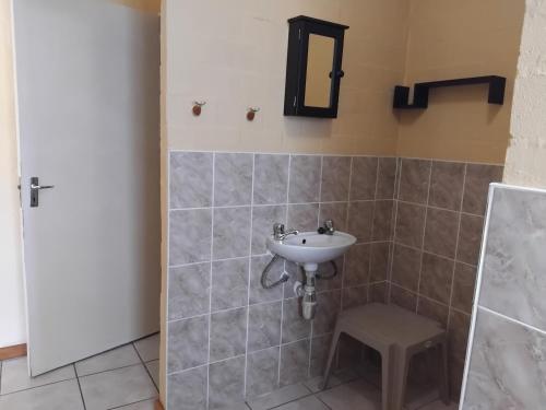 a bathroom with a sink and a stool at Magic Flame farm in Hopefield