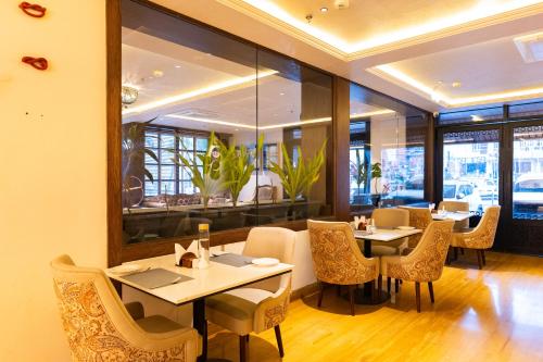 ein Restaurant mit Tischen, Stühlen und Fenstern in der Unterkunft The Naori by Alaya Stays in Udaipur