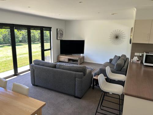 a living room with two couches and a flat screen tv at Cambridge Lodge in Cambridge