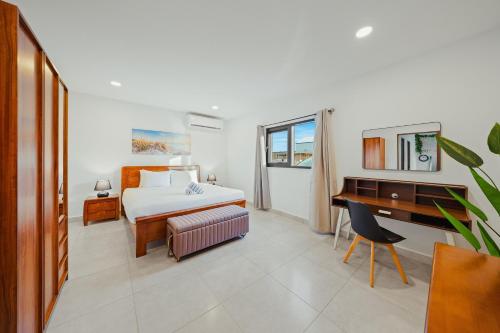 een hotelkamer met een bed en een bureau en een bureau bij Aruba Escape Spacious 5BR Villa for 12 by Bocobay in Oranjestad