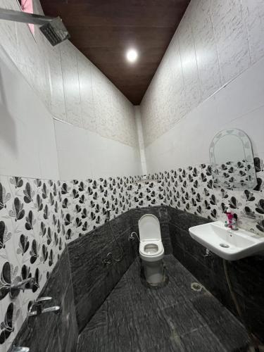 a bathroom with a toilet and a sink at Magic Restaurant Hotel in Haldwāni