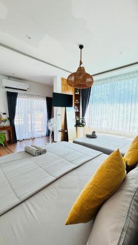 a bedroom with two beds with yellow pillows at HappyDaysVilla in Ko Larn