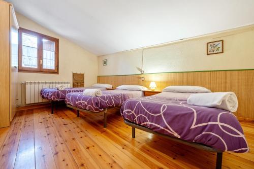 drie bedden in een kamer met houten vloeren bij Cal Marti in Farena