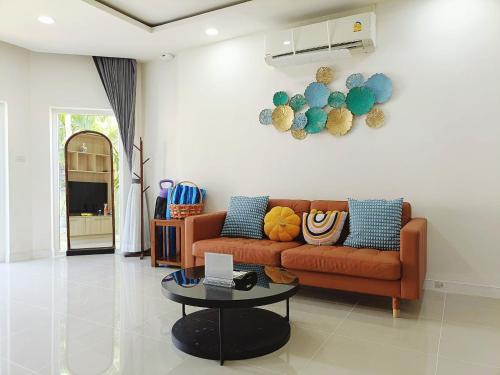 a living room with a couch and a table at 3BR Pool Villa Beach Access Patumnak Hill in Pattaya South