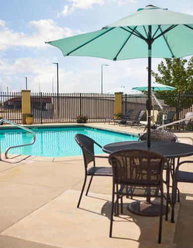 a table and chairs with an umbrella next to a pool at Hyatt Place Salt Lake City Downtown / The Gateway in Salt Lake City
