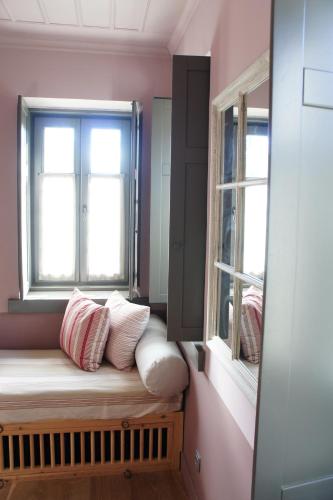 a bench in a room with two windows at "Apeiros Chora" Hotel, Zagori in Kato Pedina