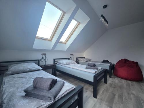 ein Dachzimmer mit zwei Betten und zwei Fenstern in der Unterkunft Domki Przystankowe 4 żywioły in Smerek