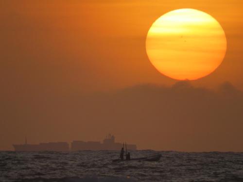 a small boat in the ocean at sunset at Paradise Bay in Beruwala