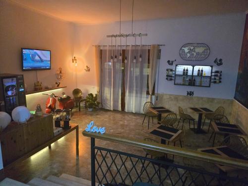 ein Wohnzimmer mit Tischen, Stühlen und einem TV in der Unterkunft THAT'S LOVE Fiumicino Jazz in Fiumicino