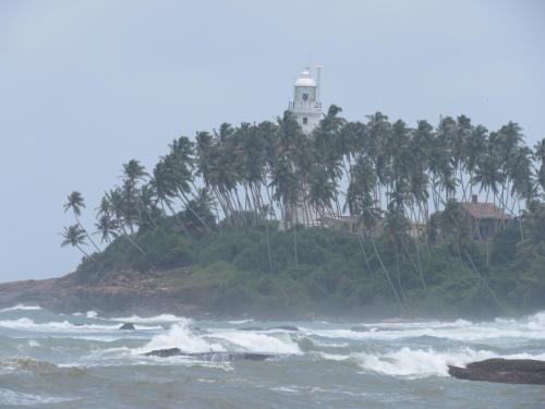 a lighthouse on an island with palm trees and the ocean at Paradise Bay in Beruwala