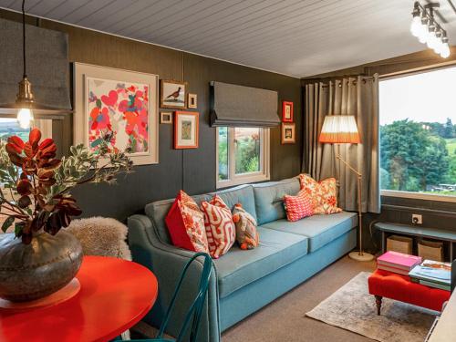 ein Wohnzimmer mit einer blauen Couch und einem roten Tisch in der Unterkunft The Game Keeper - Uk50611 in Appletreewick