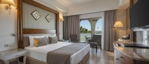 Side Star Resort Hotel - Ultra All Inclusive في سيدي: غرفة فندقية مع سرير كبير وشرفة