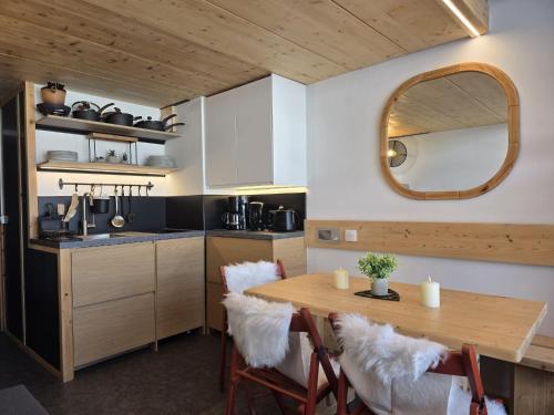 eine Küche mit einem Holztisch und einem Spiegel in der Unterkunft Arcs 1800: 5/6 people Ski Studio view Mont Blanc in Arc 1800