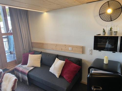 ein Wohnzimmer mit Sofa und Fernseher in der Unterkunft Arcs 1800: 5/6 people Ski Studio view Mont Blanc in Arc 1800