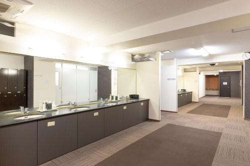 a large bathroom with two sinks and a large mirror at カプセルホテルグロリア in Beppu