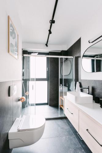 a bathroom with two sinks and a toilet and a shower at Luma Central Viewpoint with Private Underground Parking in Târgu-Mureş