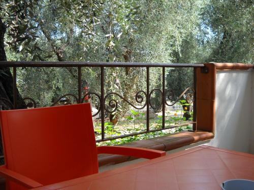 a red chair on a balcony with trees in the background at Zagare Residence in Rodi Garganico