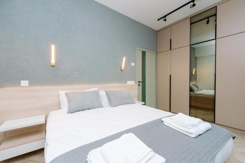 ein Schlafzimmer mit einem großen weißen Bett mit zwei Kissen in der Unterkunft Luma Central Viewpoint with Private Underground Parking in Târgu Mureș