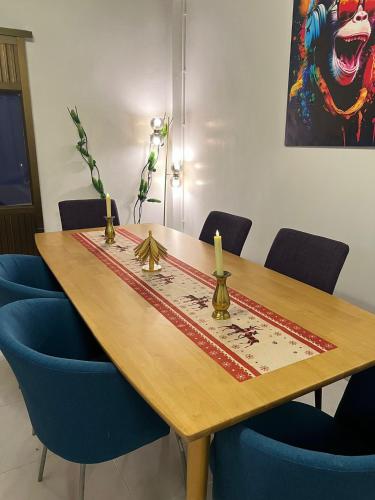 a wooden table with blue chairs around it with a picture at LA CASA in China town in Bangkok