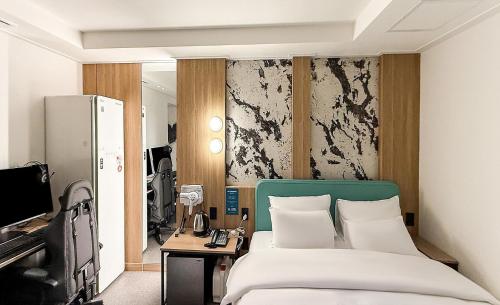 a hotel room with a bed and a television at 호텔인카페 파주금촌점 in P'aju