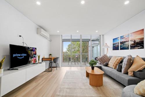a living room with a couch and a tv at Luxury 2Bed 2bath Apartment with Distance Harbour Bridge View 6km from CBD in Sydney