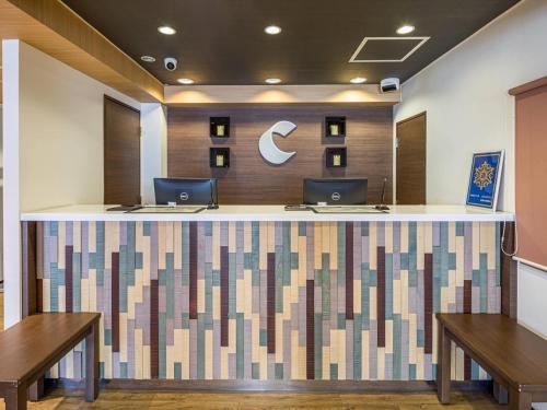 eine Lobby mit einer Theke mit zwei Computern darauf in der Unterkunft Comfort Inn Niigata Kameda in Niigata