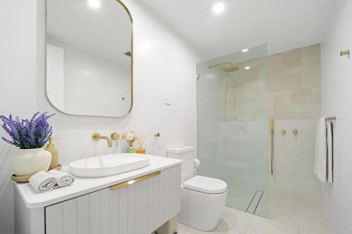 a bathroom with a sink and a toilet and a mirror at Luxury 2Bed 2bath Apartment with Distance Harbour Bridge View 6km from CBD in Sydney