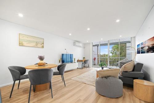 a living room with a table and chairs at Luxury 2Bed 2bath Apartment with Distance Harbour Bridge View 6km from CBD in Sydney