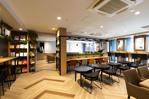 a restaurant with tables and chairs and a bar at Comfort Hotel Shin-Osaka in Osaka