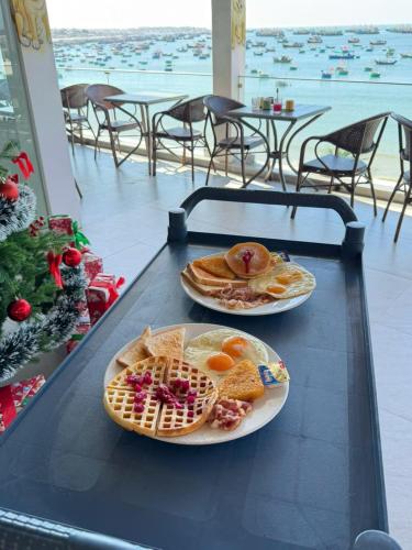 dos platos de comida en una mesa con gofres en Bay View Resort & Villas Mũi Né, en Phan Thiet