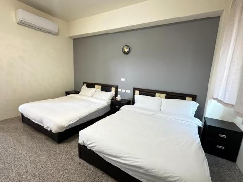 due letti in una camera d'albergo con lenzuola bianche di 香菇里啦 a An-ch'i