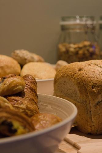 een tafel met een kom brood en een bord brood bij Bed and Breakfast L'Orée Du Bois in Waver