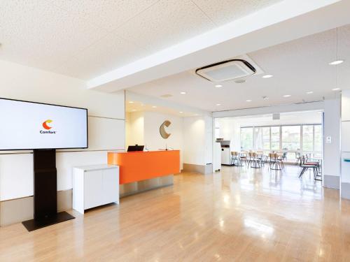 an empty room with a screen and tables and chairs at Comfort Inn Himeji Yumesakibashi in Himeji