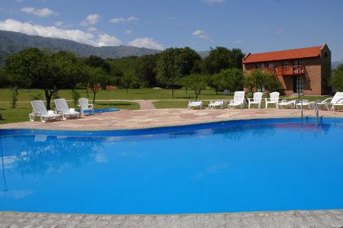 una gran piscina azul con sillas y un edificio en Campo Las Tinajas en Merlo