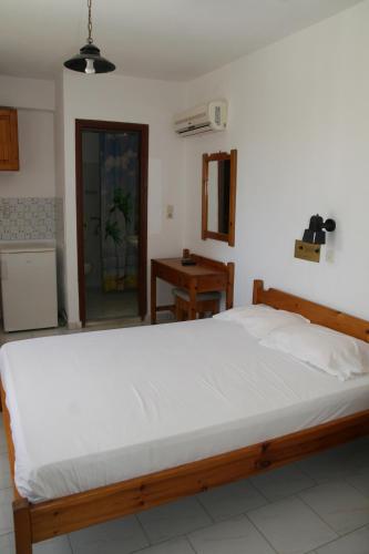 a bedroom with a large white bed in a room at Andavis Hotel in Kardamaina