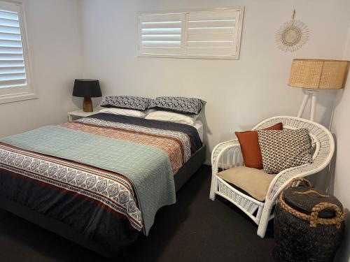 a bedroom with two beds and a chair at Harrington Haven in Harrington