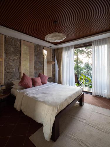 a bedroom with a large bed and a large window at Deoja Forest Stay in Darjeeling