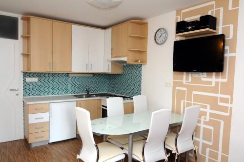 a kitchen with a table and white chairs at Zeleni Apartment Rogla in Zreče