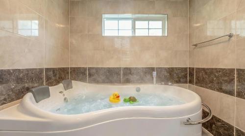 un bagno con vasca e 2 anatre di gomma di Gapyeong Gently Pension a Gapyeong