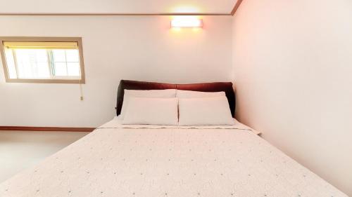 una piccola camera da letto con un letto con due cuscini di Gapyeong Gently Pension a Gapyeong