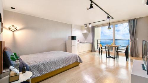 una camera da letto con un letto e un tavolo con sedie di Yeosu Harushimpyo Pension a Yeosu