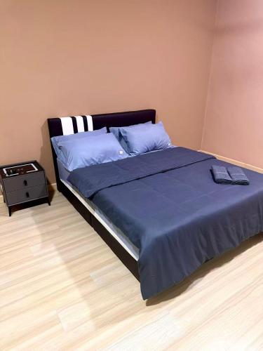 a bedroom with a large bed with a blue blanket at HOMESTAY Mu in Simpang Ampat