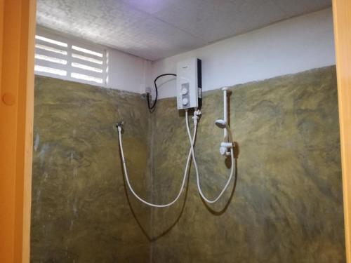 a shower in a bathroom with a hose attached to a wall at Sigiri Forest View in Sigiriya